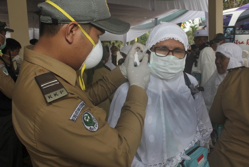 Peugas kesehatan memeriksa suhu tubuh seorang haji dengan alat pengukur saat kedatangan jamaah haji di Asrama Haji Provinsi Bengkulu. 111 Calon Jamaah Haji Rejang Lebong tidak Kena Penambahan Bipih