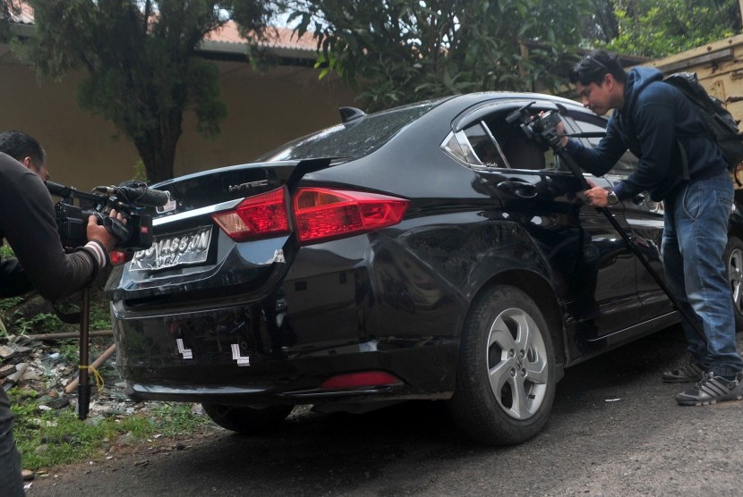 Pewarta mengambil gambar kondisi mobil yang menjadi barang bukti kasus penembakan mobil oleh polisi di Lubuk Linggau, di Mapolda Sumsel, Palembang, Jumat (21/4). 