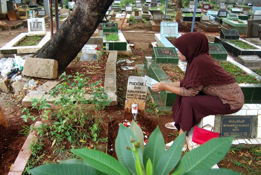 Peziarah berdoa di depan makam sanak saudaranya di kompleks pemakaman Pejaten Barat, Jakarta Selatan. Pengetatan PPKM mikro membuat Pemkot melarang kegiatan ziaran makam mulai Kamis  (24/6).