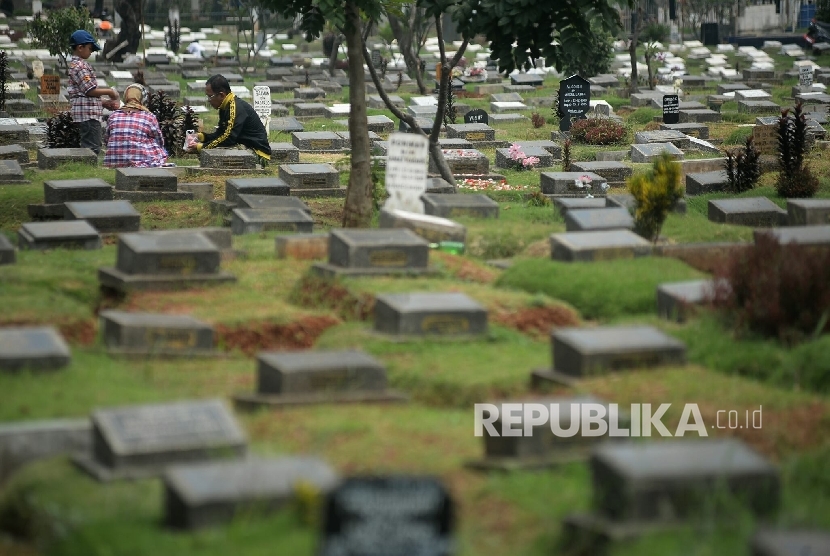  Peziarah berdoa di makam anggota keluarga (ilustrasi)