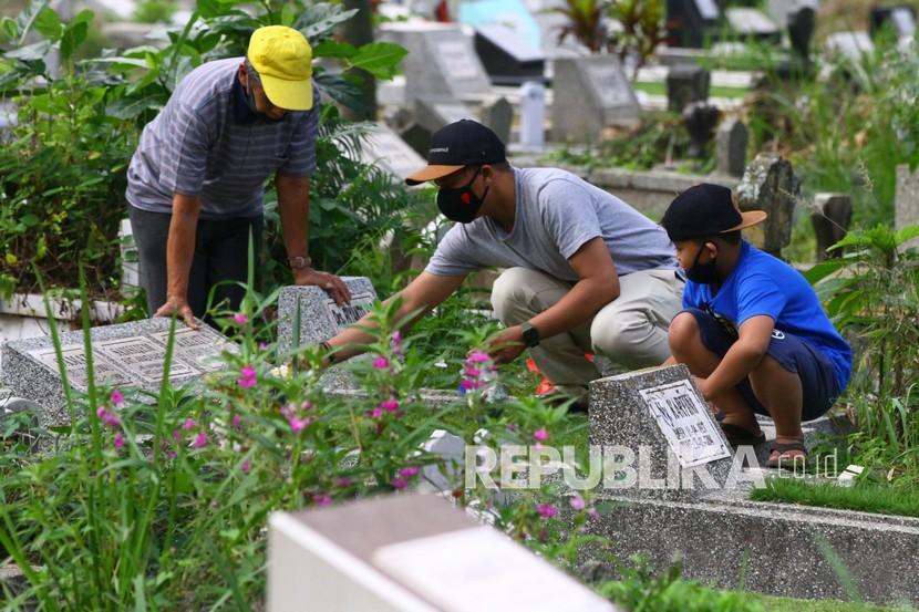 Peziarah menaburkan bunga di atas makam anggota keluarganya di Tempat Pemakaman Umum (TPU) Samaan, Malang, Jawa Timur, Rabu (12/5/2021). (Ilustrasi)