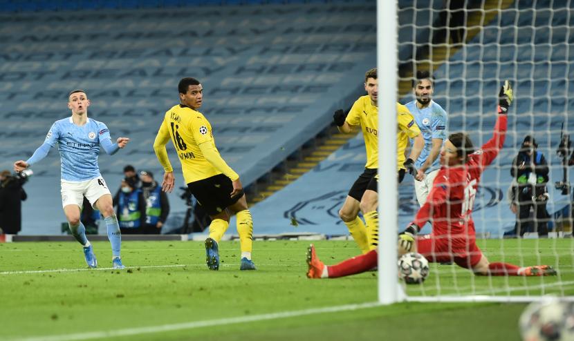 Phil Foden dari Manchester City mencetak gol ke gawang Borussia Dortmund.