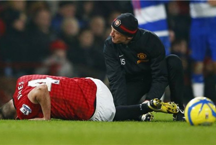 Phil Jones (kiri), pemain Manchester United, mendapat perawatan di lapangan saat menghadapi Reading di laga Piala FA di Old Trafford, Manchester, pada 18 Februari. 