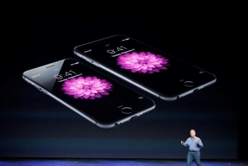 Phil Schiller, Senior Vice President at Apple Inc., speaks about the iPhone 6 (foreground) and the iPhone 6 Plus during an Apple event at the Flint Center in Cupertino, California, September 9, 2014.