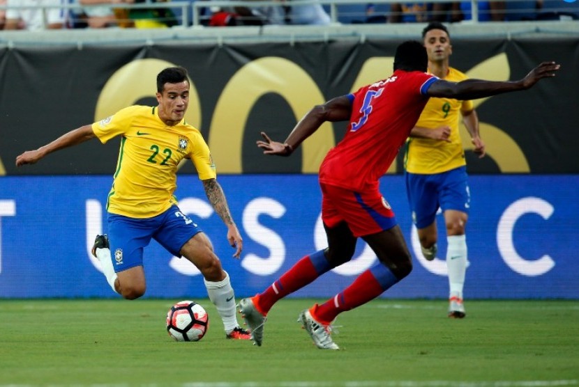 Philippe Coutinho (kiri) membawa bola coba melewati pemain Haiti. Coutinho mencetak hat-trick ke gawang Haiti pada lanjutan Copa America Centenario 2016.