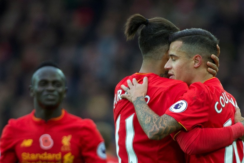 Philippe Coutinho mendapatkan selamat dari Roberto Firmino seusai mencetak gol ke gawang Watford, akhir pekan lalu. Liverpool kini berada di puncak klasemen Liga Primer Inggris.