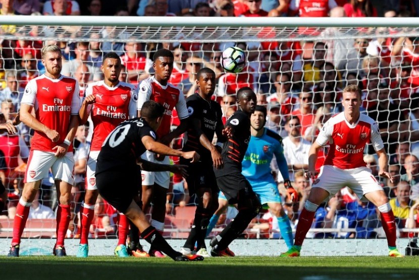 Philippe Coutinho saat mengambil tendangan bebas yang berbuah gol ke gawang Arsenal.