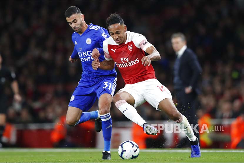 Pierre-Emerick Aubameyang berebut bola dengan  Rachid Ghezzal  pada laga Liga Inggris  antara Arsenal dan Leicester City di  Emirates stadium, London, Selasa (23/10) dini hari. 