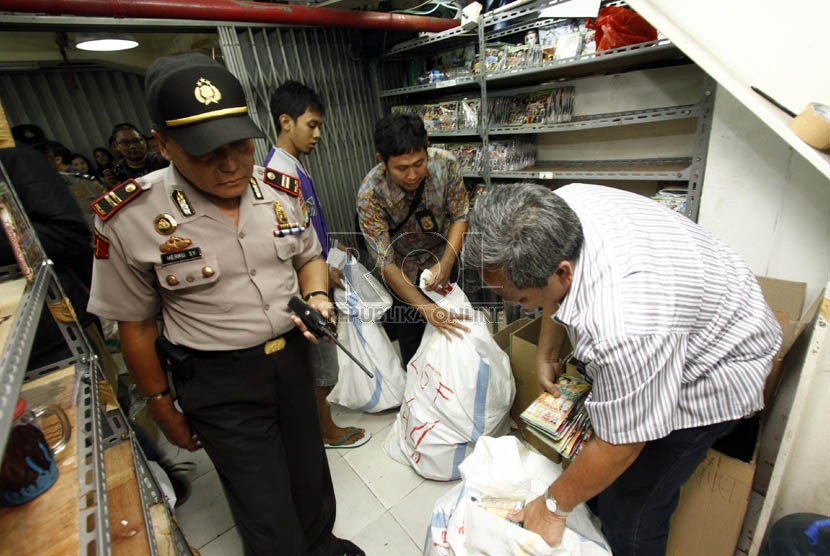 Pihak Kepolisian dan Tim Penyidik Ditjen Hak Kekayaan Intelektual (HKI) Kemenkum HAM menggerebek para pedagang DVD bajakan di Plaza Glodok,Jakarta Barat (1/2).