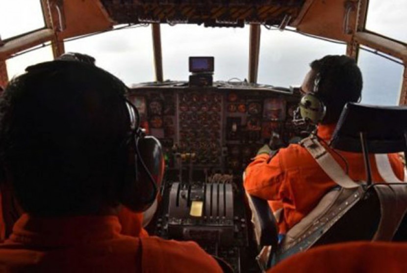 Pilot dan petugas di pesawat C-130 Hercules milik AU Indonesia sedang melakukan pencarian.