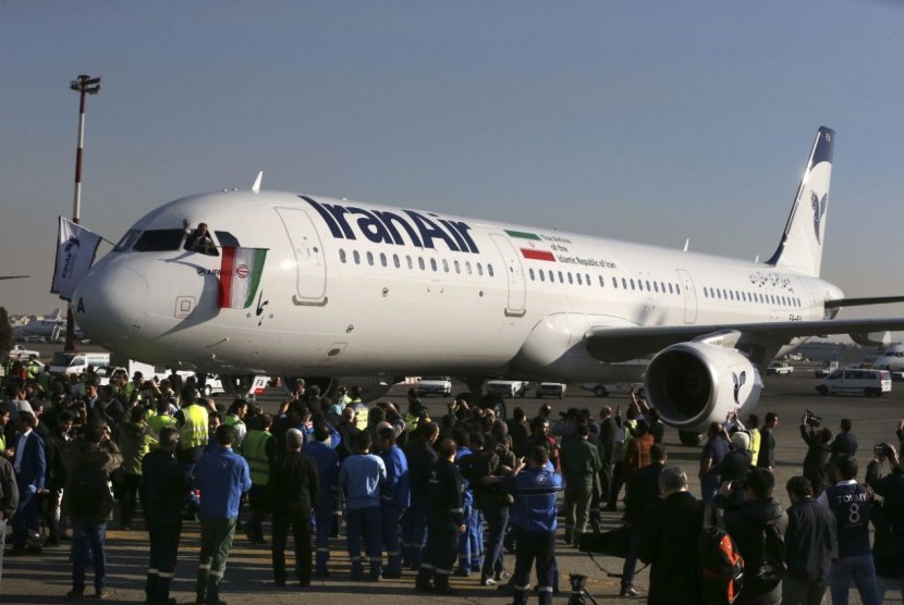Pilot melambaikan bendera Iran setelah mendaratkan pesawat Airbus baru di Bandara Mehrabad, Teheran, Kamis (12/1). Pesawat tersebut dibeli Iran pertama dalam 40 tahun terakhir.