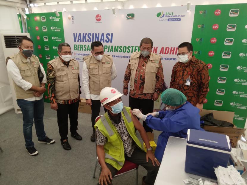 Pimpinan BPJAMSOSTEK dan Direksi PT Adhi Karya saat menyaksikan pekerja yang divaksinasi covid-19 di area pekerjaan Proyek Pembangunan Prasarana LRT Jabodebek, Stasiun Pancoran, Jumat (3/8).
