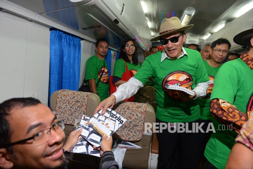  Pimpinan Komisi Pemberantasan Korupsi (KPK) Saut Situmorang memberikan majalah kepada penumpang kereta api tujuan Malang usai melakukan aksi kampanye Ngamen Anti Korupsi yang diselenggarakan di Stasiun Gambir, Jakarta, Jumat (13/5).   (Republika/Raisan Al