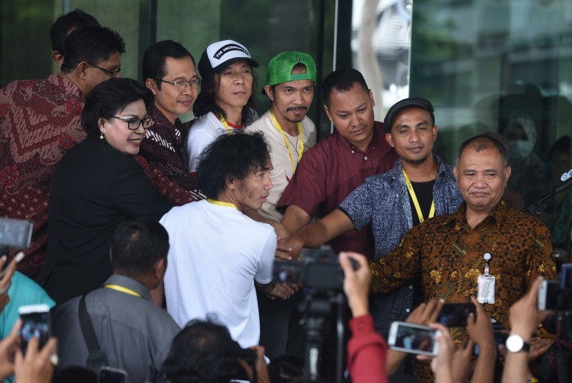 Pimpinan KPK Agus Rahardjo (kanan), Laode Muhammad Syarif (kiri), Basaria Panjaitan (kedua kiri) dan Alexander Marwata (ketiga kiri) saling berjabatan tangan dengan personel grup band Slank sebelum Slank menggelar konser di halaman Gedung KPK, Jakarta, Sen