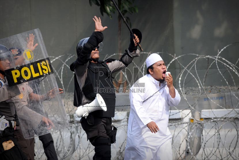   Pimpinan pengunjuk rasa dan polisi berusaha menenangkan massa saat terjadinya kericuhan dalam aksi unjuk rasa di depan Kedubes Amerika Serikat di Jakarta, Senin (17/9).  (Aditya Pradana Putra/Republika)