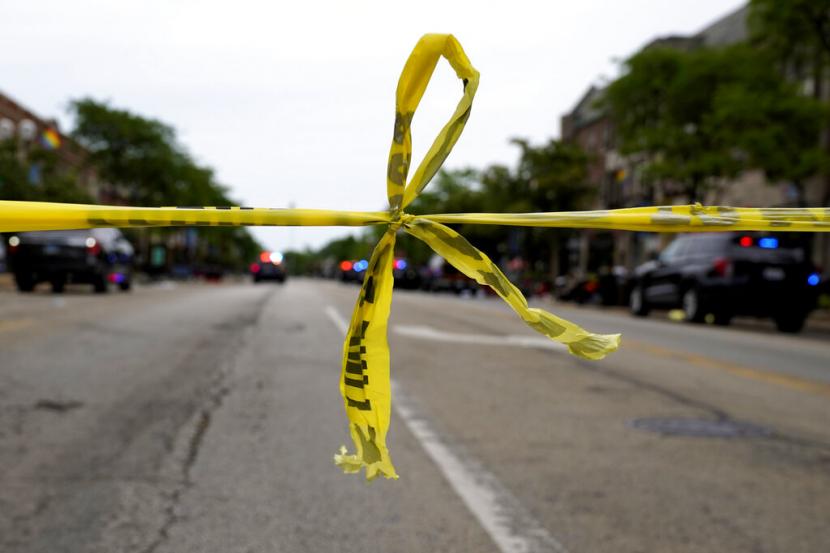 Pita (garis) polisi digantung di sudut Central Avenue dan Green Bay Rd., di Highland Park, Illinois, pinggiran Chicago, Senin, 4 Juli 2022, setelah penembakan massal di parade Highland Park Fourth of July.