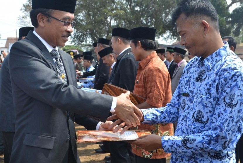  Pj. Bupati Pangandaran Daud Achmad (kiri) mengapresiasi sejumlah PNS dalam puncak peringatan Hari Jadi Kabupaten Pangandaran ke-3 di Pangandaran, belum lama ini. 