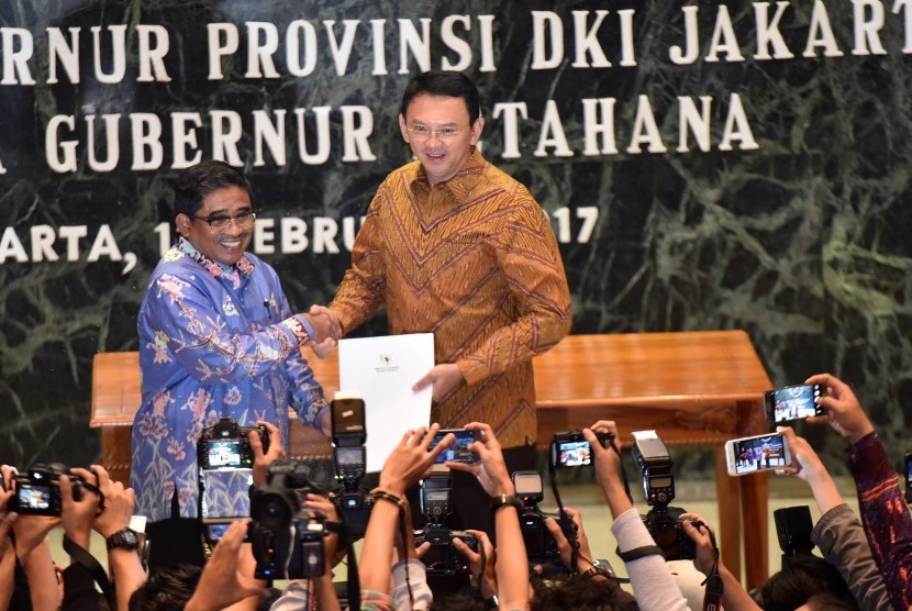 Plt Gubernur DKI Jakarta Soni Sumarsono (kiri) menyerahkan laporan nota singkat kepada Gubernur Petahana Basuki Tjahaja Purnama di Balai Kota Jakarta, Sabtu (11/2). 