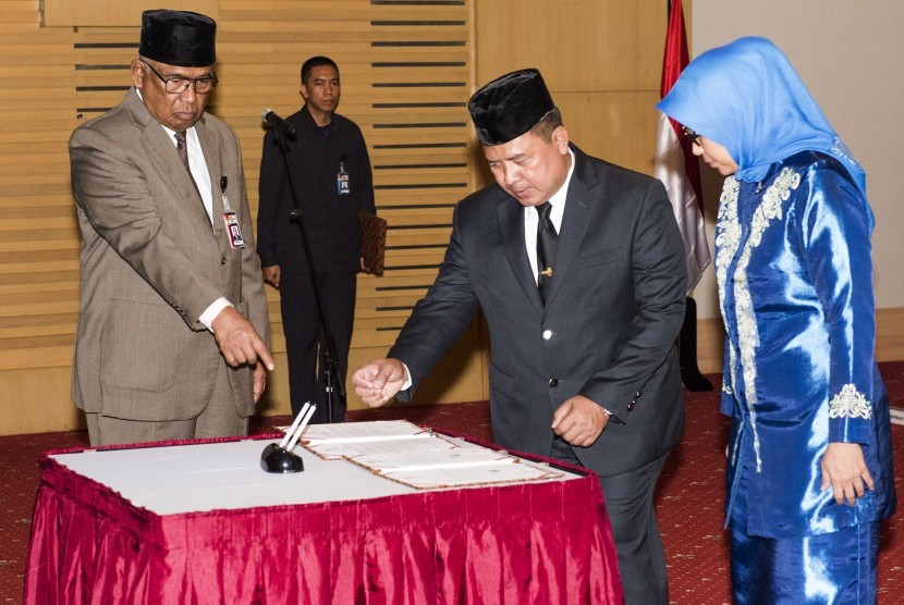 Plt Ketua KPK Taufiqurachman Ruki (kiri) mengarahkan Kepala Biro Hukum KPK yang baru Kombes Pol Setiadi (kedua kanan) dan istri untuk menandatangani surat terima jabatan saat upacara pelantikan di gedung KPK, Jakarta, Rabu (16/9). 