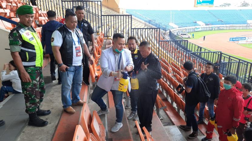 PMI Kota Bandung bersama Dinas Kesehatan Kabupaten Bandung melakukan penyemprotan disinfektan pada kursi penonton di Stadion Si Jalak Harupat, Kabupaten Bandung, Ahad (15/3). (Republika/Hartifiany Praisra)