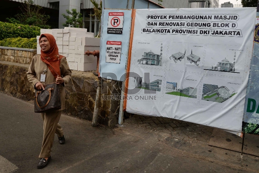 PNS melintass di spanduk desain pembangunan Masjid Fatahillah di area Balai Kota DKI Jakarta, Rabu (21/10). Pembangunan Masjid Fatahillah ang ditargetkan selesai pada Desember 2015 menghabiskan anggaran hingga Rp 18,8 miliar.