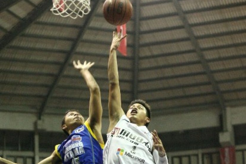 Point guard Aspac Andakara Prastawa Dhyaksa (kanan) berusaha memasukkan bola saat melawan Bandung Utama, Rabu (10/12).