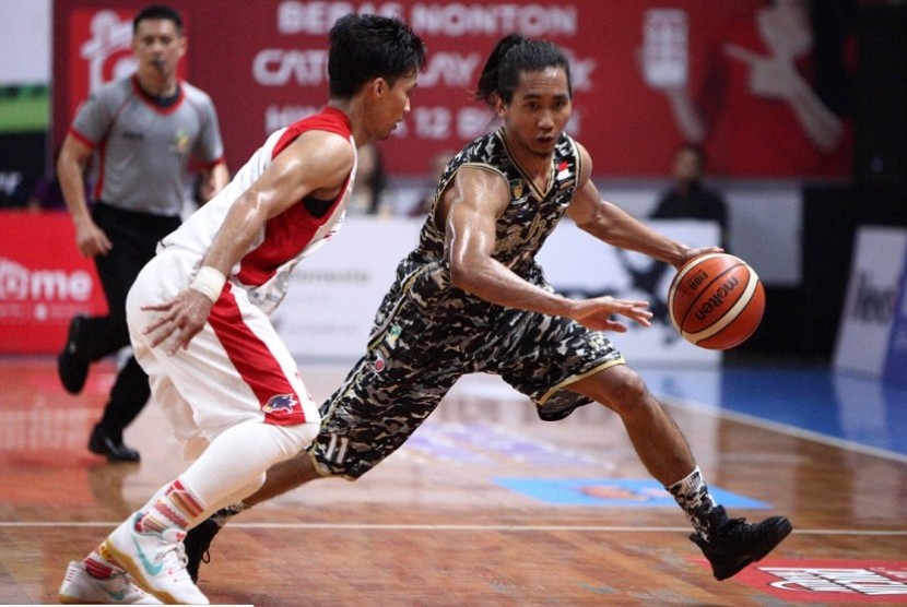 Point guard CLS Knights Arif Hidayat membawa bola berusaha melewati guard Bank BJB Garuda Bandung dalam laga play-off IBL Pertalite di GOL Kertajaya, Surabaya, Sabtu (1/4).