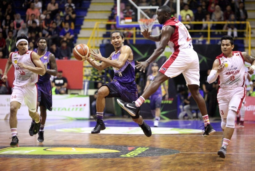 Point guard CLS Knights Arif Hidayat (tengah) saat melakukan fast break ke pertahanan Bank BJB Garuda Bandung.