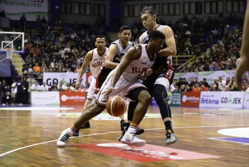 Point guard Pelita Jaya Basketball Wayne Bradford membawa bola melewati penjagaan pemain Stapac.