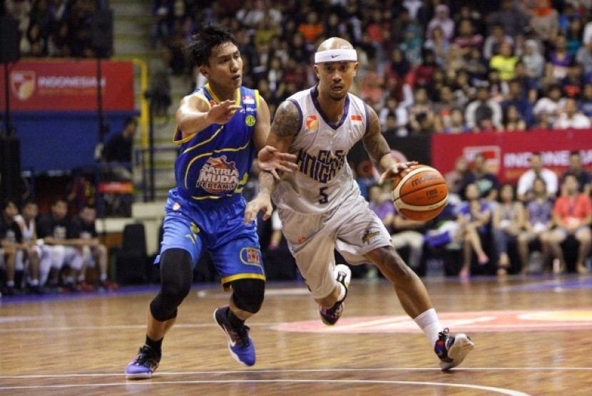 Point guard Satria Muda Pertamina Hardianus Lakudu (kiri) menjaga pointguard CLS Knights Mario Wuysang.