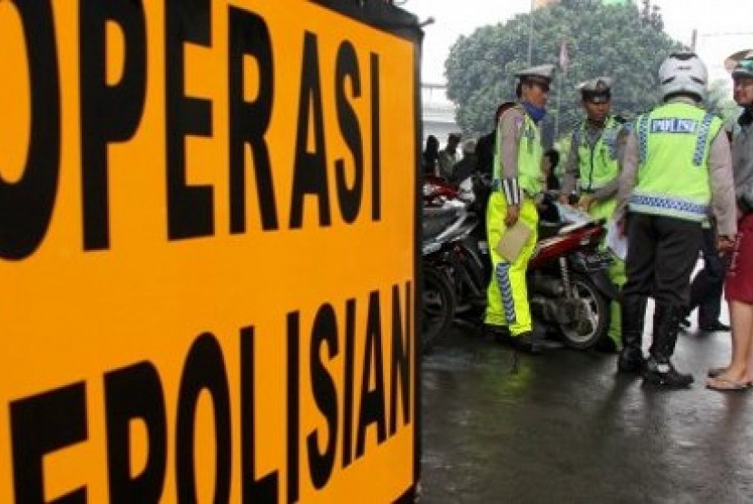 Polantas membuat surat tilang untuk pengendara motor ketika berlangsungnya Operasi Patuh Jaya di kawasan Kemanggisan Utama, Jakarta Barat, JumaT (5/7). Oparasi tersebut digelar untuk meningkatkan ketertiban dan kepatuhan berlalu lintas