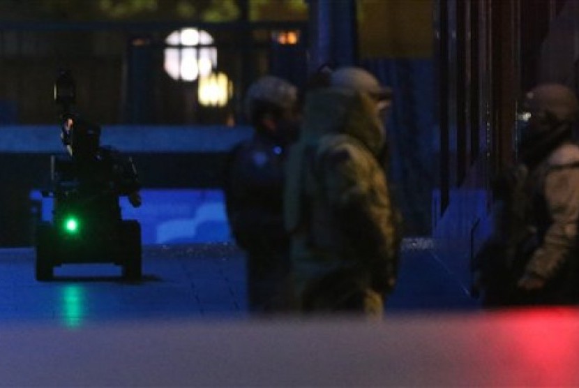 Police bomb squad bomb disposal robot top left, moves into place during a cafe siege in the central business district of Sydney , Australia, Tuesday, Dec. 16, 2014.