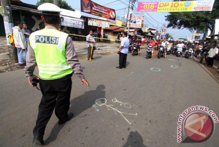 Police officers mark and install police lines in the accident site where one policeman got shot until dead in Jalan Otto Iskandar Dinata, Tangerang, Banten Province. The victim was First Adjunct Police Inspector Dwijatna. 