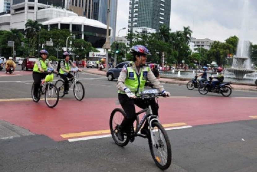 Polisi memakai sepeda di Jalan MH Thamrin, dmana Car Free Night akan digelar di jalan tersebut pada malam tahun baru.   