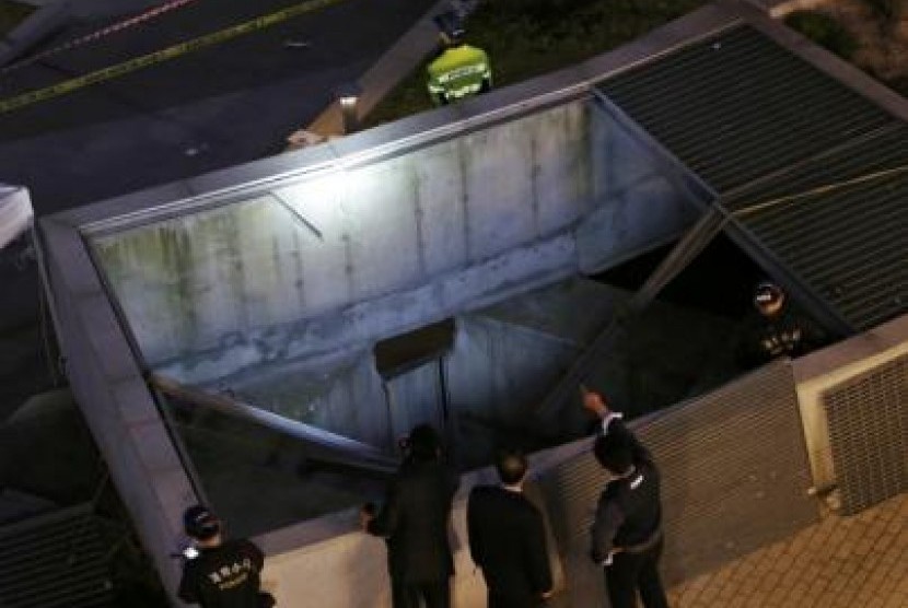Police officials examine the scene of an accident at a shopping district in Seongnam October 17, 2014. 
