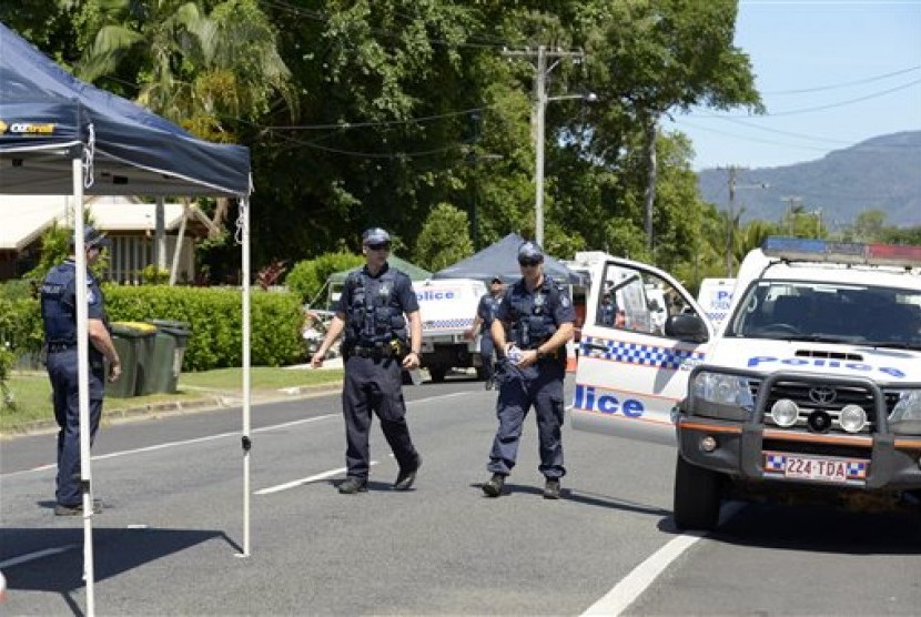 Police patrol near a house where eight children have been found dead in a Cairns suburb in far north Queensland, Australia, Friday Dec 19, 2014. 