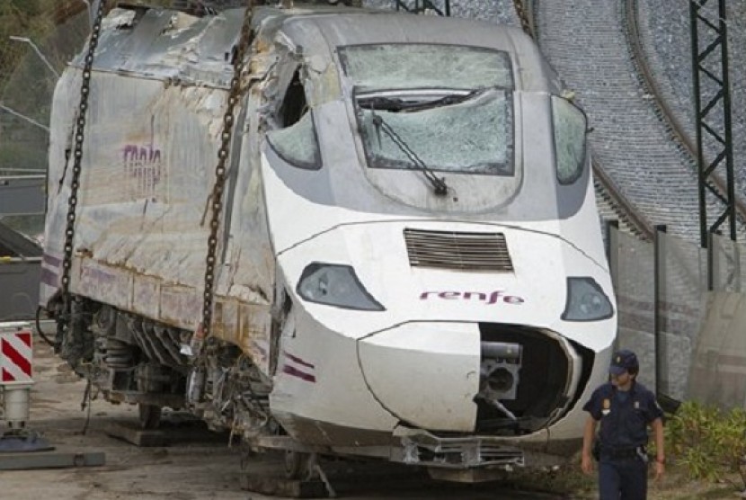 Police stand guard as a wreckage of a crashed train is seen ready to be deposited in Santiago de Compostela, Spain, Sunday July 28, 2013. 