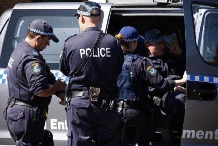 Police talk outside a house that was involved in pre-dawn raids in the western Sydney suburb of Guilford September 18, 2014.