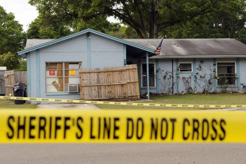 Police tape surrounds a home where a sinkhole opened up and swallowed a Florida man in Seffner, Florida, March 1, 2013. 