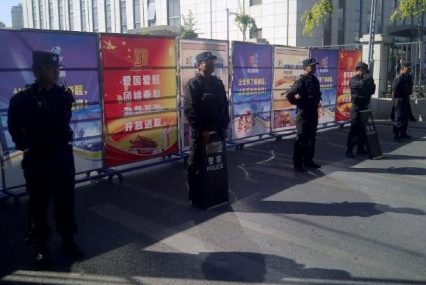 Policemen in riot gear guard a checkpoint on a road near a courthouse where ethnic Uighur academic Ilham Tohti's trial is taking place in Urumqi, Xinjiang Uighur Autonomous Region September 17, 2014.