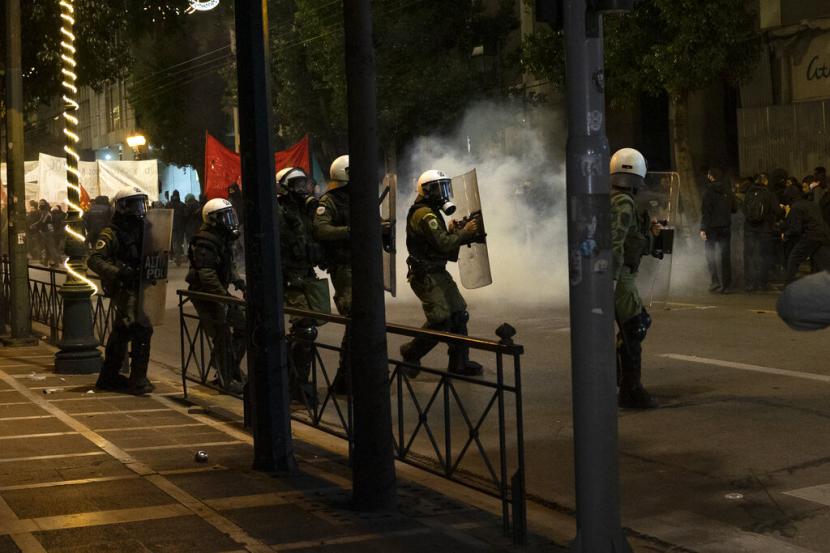 Polisi anti huru hara berusaha membubarkan demonstran selama unjuk rasa setelah kematian seorang remaja, di Athena, pada Selasa, 13 Desember 2022. Ribuan pengunjuk rasa berbaris melalui kota Yunani utara Thessaloniki dan Athena Selasa malam, ketika para pemimpin komunitas Roma mengajukan banding untuk tenang setelah kematian seorang remaja yang ditembak di kepala minggu lalu selama pengejaran polisi atas tagihan pompa bensin yang diduga belum dibayar.