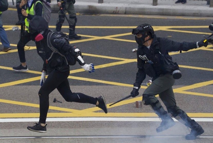 Polisi antihuru-hara Hong Kong bentrok dengan demonstran yang menyerukan reformasi pemilihan dan boikot partai Komunis China di Hong Kong, Ahad (19/1).