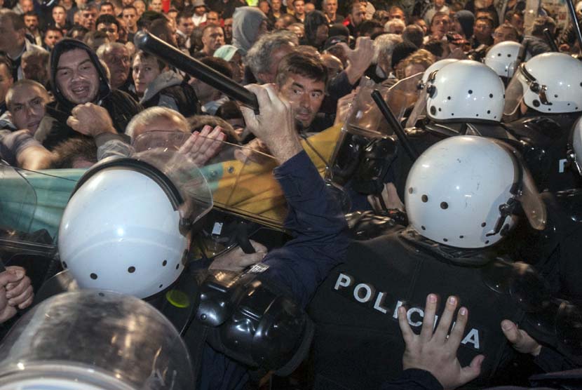 Polisi antihuru-hara terlibat bentrok dengan demonstran di depan gedung parlemen di ibukota Podgorica, Montenegro, Sabtu (17/10). 