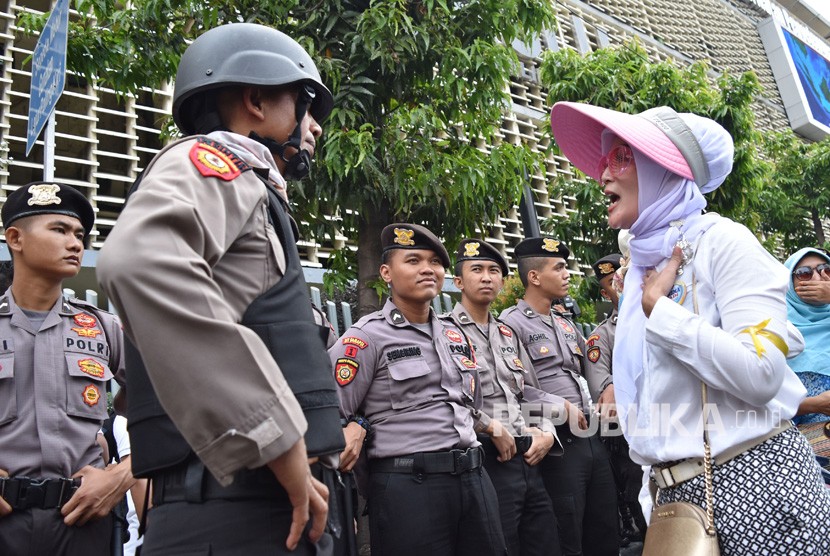 Polisi berdialog dengan salah satu pengunjuk rasa menuntut diusutnya dugaan kecurangan Pemilu 2019 di Kantor Bawaslu RI, Jakarta, Kamis (9/5). 