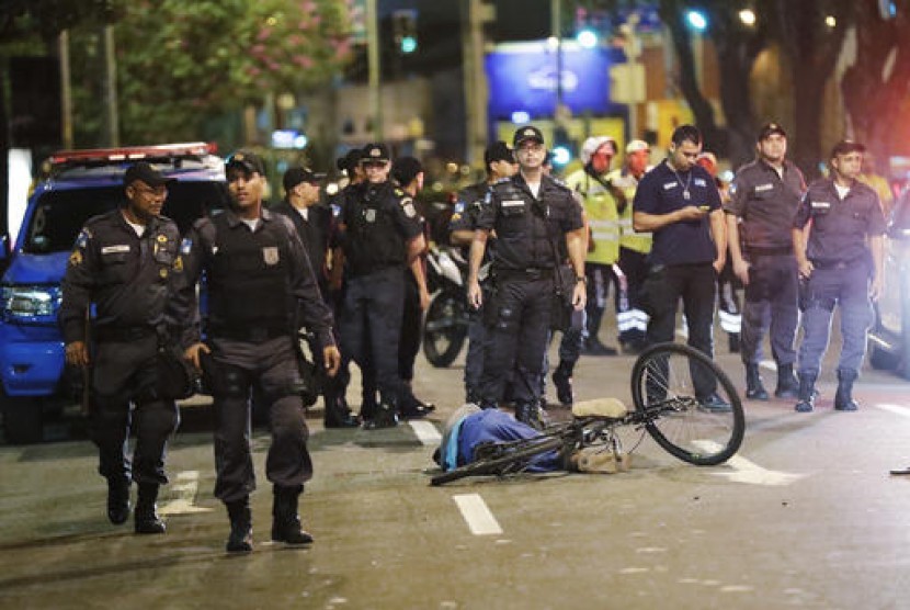 Polisi berdiri dekat jasad pria yang tertembak dan tewas dekat Stadion Maracana usai upacara pembukaan Olimpiade Musim Panas 2016 di Rio de Janeiro, Brasil, Sabtu, 6 Agustus 2016.