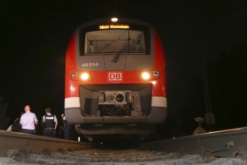 Polisi berdiri dekat sebuah kereta di Wuerzburg, selatan Jerman, Senin malam, 18 Juli 2016. Terjadi serangan kapak di kereta itu yang melukai empat orang.