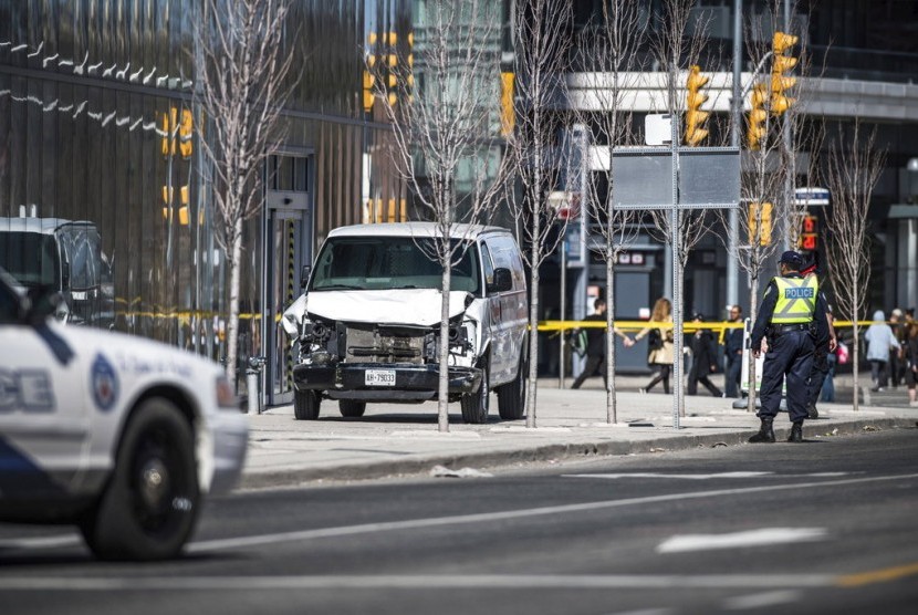 Polisi berdiri di dekat van yang digunakan pelaku untuk menabrak pejalan kaki di Toronto, Kanada, Senin (23/4)