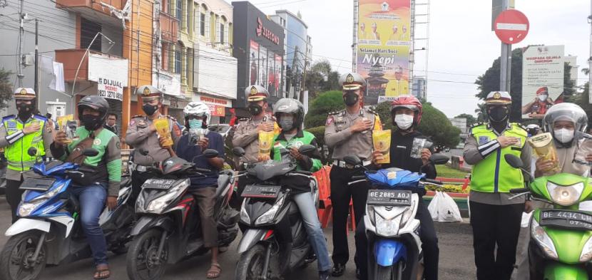 Polisi beri hadiah minyak goreng bagi pengendara yang tetib lalu lintas di Bandar Lampung, Senin (7/3). 