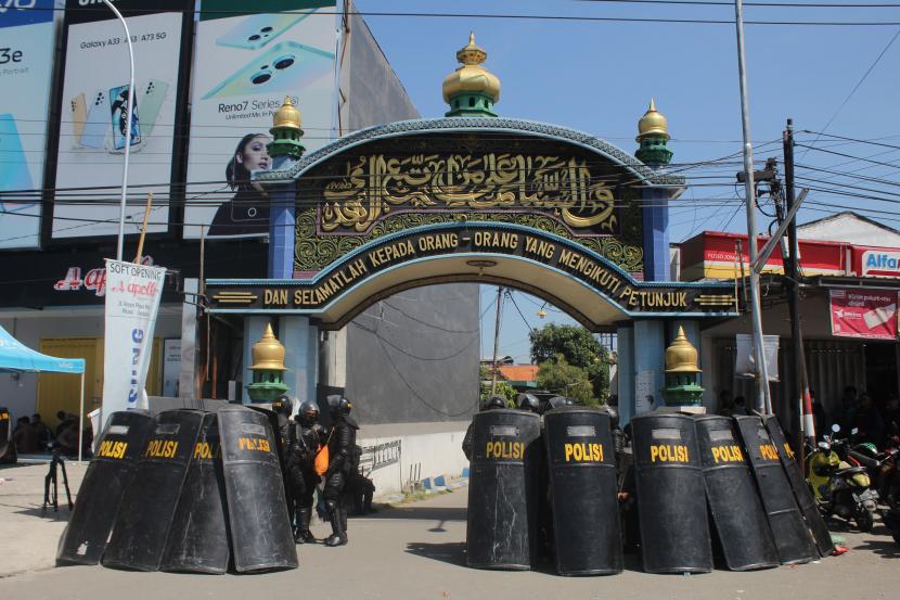 Polisi berjaga di depan gerbang Pondok Pesantren Shiddiqiyyah Ploso saat proses upaya penangkapan Moch Subchi Azal Tsani (MSAT) di Jombang, Jawa Timur, Kamis (7/7/2022). Dalam proses tersebut, polisi mengamankan puluhan orang yang menghalangi upaya jemput paksa MSAT. 