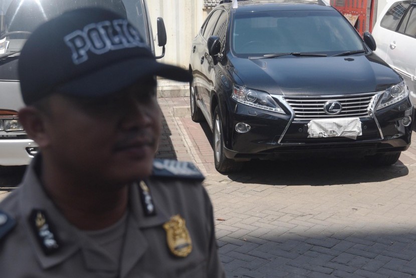 Polisi berjaga di depan mobil Toyota Lexus yang diamankan dari operasi tangkap tangan (OTT) KPK di Gedung KPK, Jakarta, Jumat (1/4). 